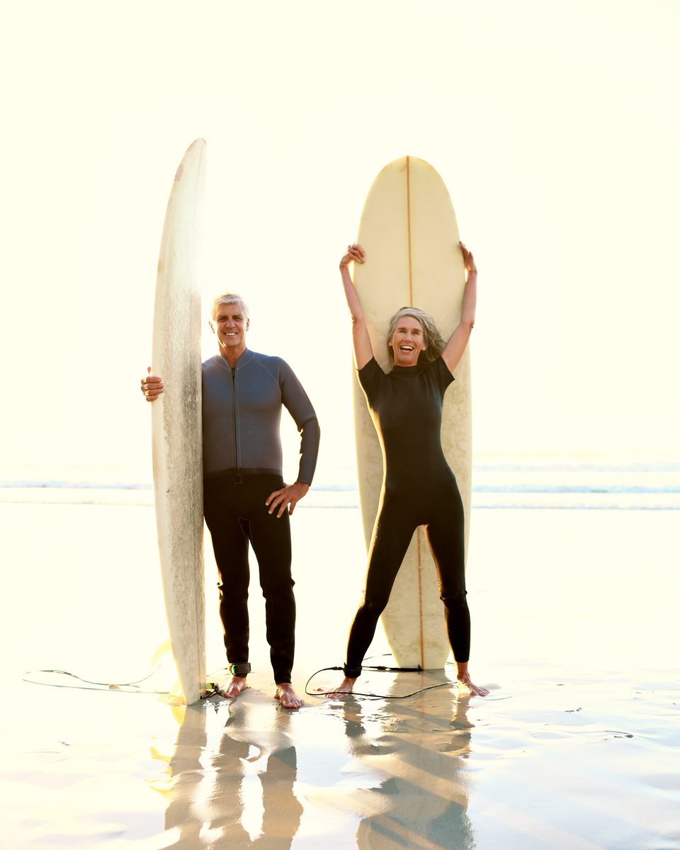 Two surfers standing with boards at the shoreline