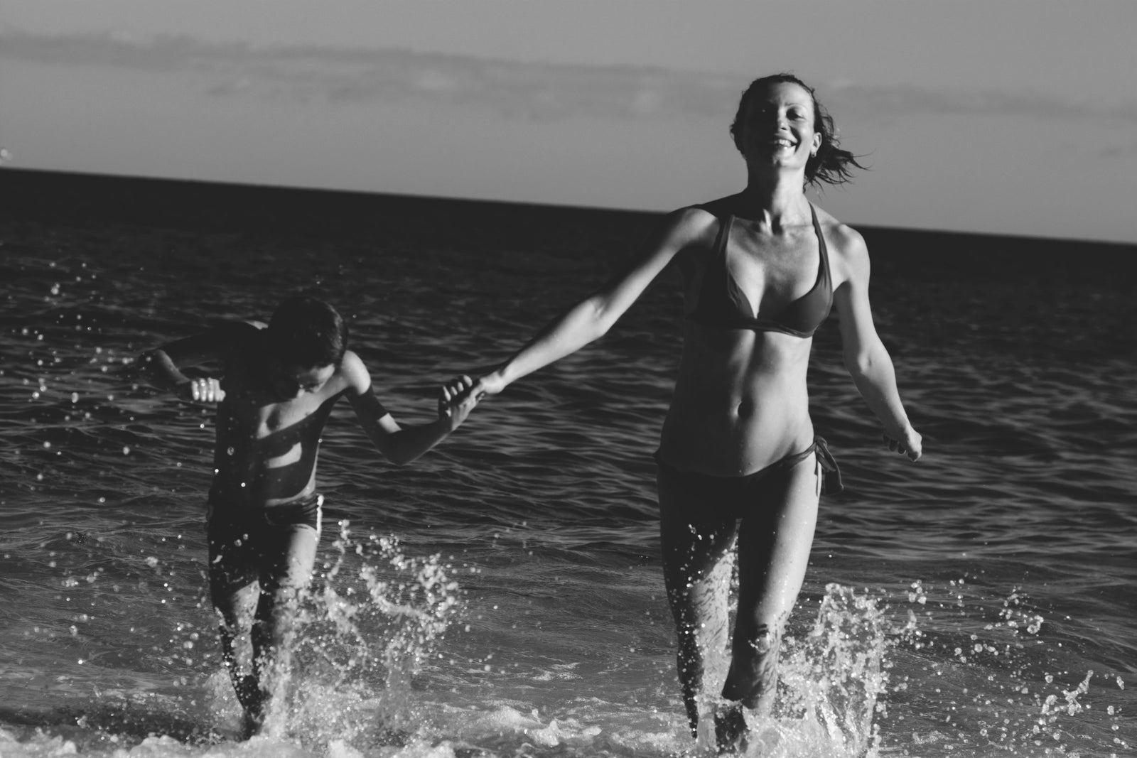 Woman running through shallow water at the beach