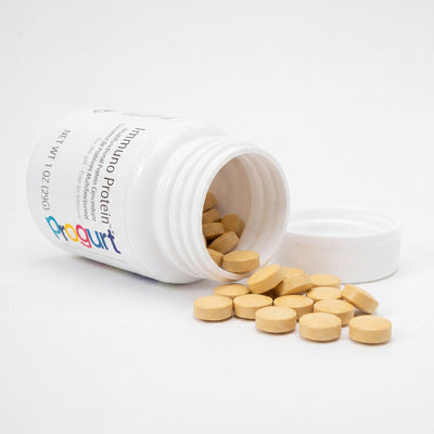 Immuno Protein inside — a tipped jar with tablets spilled on seamless white